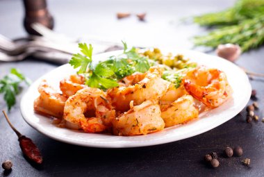 Tabağında yeşil bezelye olan kızarmış karides.