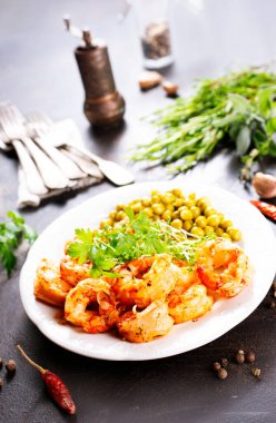 Tabağında yeşil bezelye olan kızarmış karides.