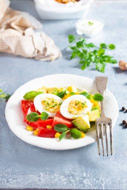 Kahvaltıda dilimlenmiş avokado, haşlanmış yumurta ve kızarmış somon.