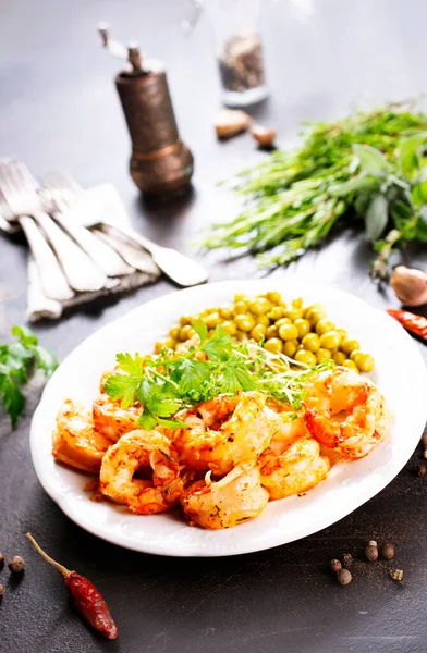 Tabağında yeşil bezelye olan kızarmış karides.