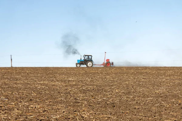 Trattore Blu Con Una Seminatrice Rossa Lavora Sul Campo Una — Foto Stock