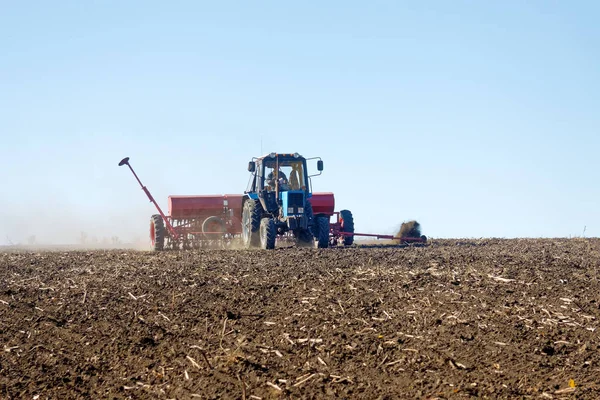 Blå Traktor Med Röd Seeder Fungerar Fältet Solig Höst Dag — Stockfoto