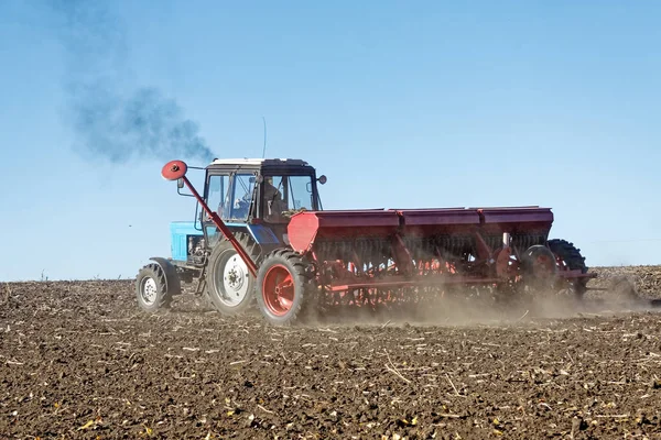 Trator Azul Com Uma Semeadora Vermelha Trabalha Campo Dia Outono — Fotografia de Stock