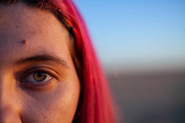 Adam gülümsüyor ve sarı arka planda poz veriyor.