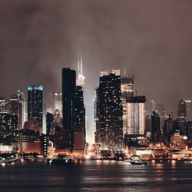 Manhattan şehir merkezi gökdelenleri ve New York City gökyüzü geceleri sisli.