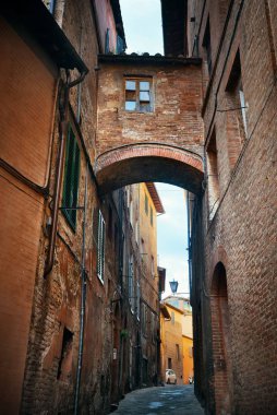 Siena, İtalya 'da eski binalar ve kemerli sokak manzarası.