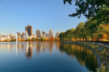 Central Park 'ın doğu yakasındaki gökdelenler New York' ta sonbaharda göl üzerinde..