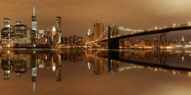 Brooklyn Köprüsü'nün yansımaları ile gece Manhattan Downtown kent manzaralı