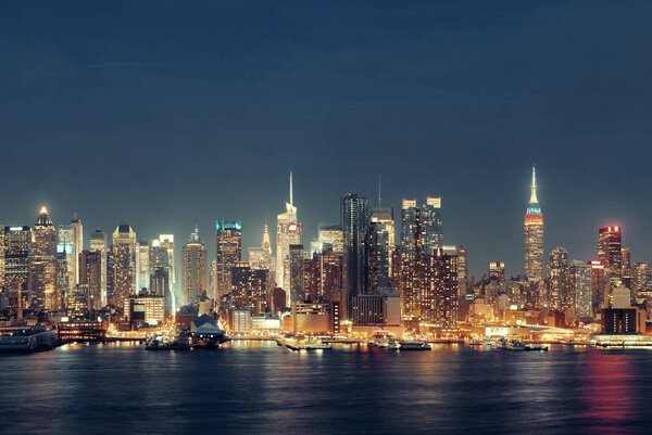 Midtown skyline over Hudson River in New York City with skyscrapers at night