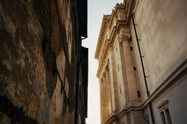 Alley with old buildings and National Monument to Victor Emmanuel II in Rome, Italy.