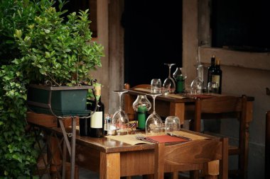 Masalar ve cam bardaklar Venedik, İtalya 'da sokakta misafirleri bekliyor..