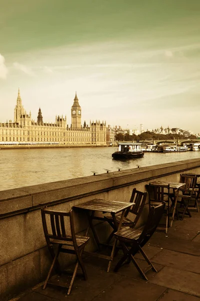 在旁的泰晤士河与大笨钟和伦敦议会上院的椅子 — 图库照片