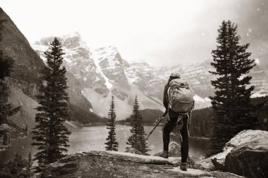 Kar ile uzun yürüyüşe çıkan kimse buzultaş göl dağ Banff National Park Kanada'da kar yağıyordu günde şapkalı.