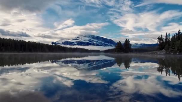 ジャック湖タイムラプス Cloudscape と雪山反射 カナダのバンフ国立公園に — ストック動画