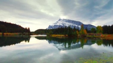 Banff National Park, Amerika Birleşik Devletleri içinde yansıma ile göl üzerinde ahşap köprü kar dağ ve sonbahar yaprakları.