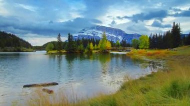 Otlak waterfront kar dağ ve göl ile sonbahar yaprakları yansımaları timelapse Banff National Park, Amerika Birleşik Devletleri içinde kaydırma.