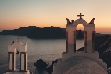 Santorini geceleri Yunanistan 'daki binalar ve çan kulesiyle gökyüzüne yükseliyor.