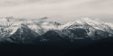 Günbatımında kar ve bulutla kaplı Krallar Kanyonu Dağı