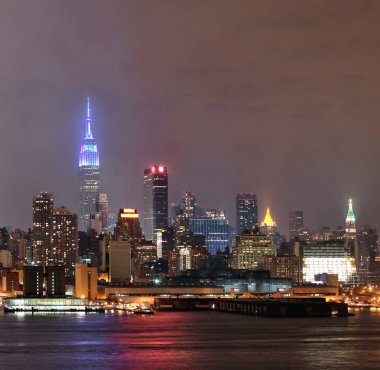 Manhattan şehir merkezi gökdelenleri ve New York City gökyüzü geceleri sisli.