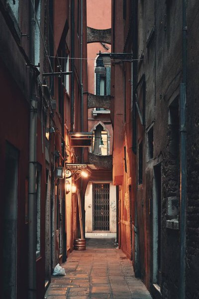 Alley view with historical buildings at night in Venice, Italy.
