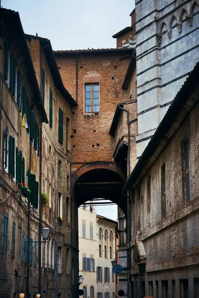 Siena, İtalya 'da eski binalar ve kemerli sokak manzarası.
