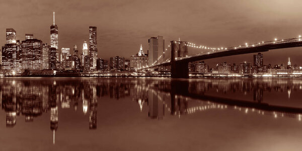 Manhattan Downtown urban view with Brooklyn bridge at night with reflections