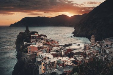 Vernazza 'da renkli bir gün batımı Cinque Terre, İtalya' da kayalar üzerinde binalar.