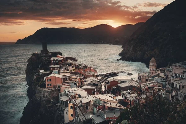 Vernazza 'da renkli bir gün batımı Cinque Terre, İtalya' da kayalar üzerinde binalar.