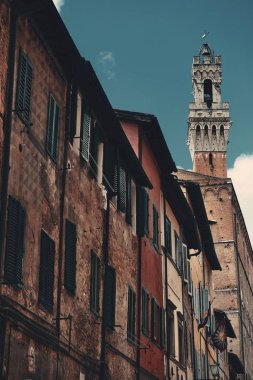 Siena, İtalya 'da eski binalar ve çan kulesiyle sokak manzarası.