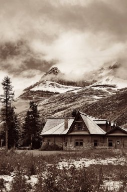 Banff Ulusal Parkı 'nda karlı dağ ve ormanlı bir kulübe.