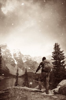 Moraine Gölü 'ndeki yürüyüşçü kar yağışlı bir günde Kanada' daki Banff Ulusal Parkı 'nın karlı tepesinde