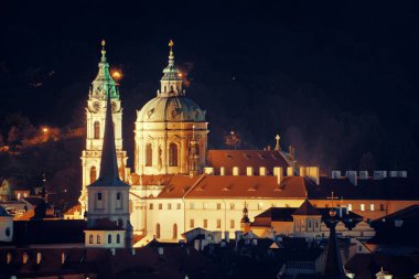 Geceleri Çek Cumhuriyeti 'nde kilise ve kubbeli Prag silueti manzarası.