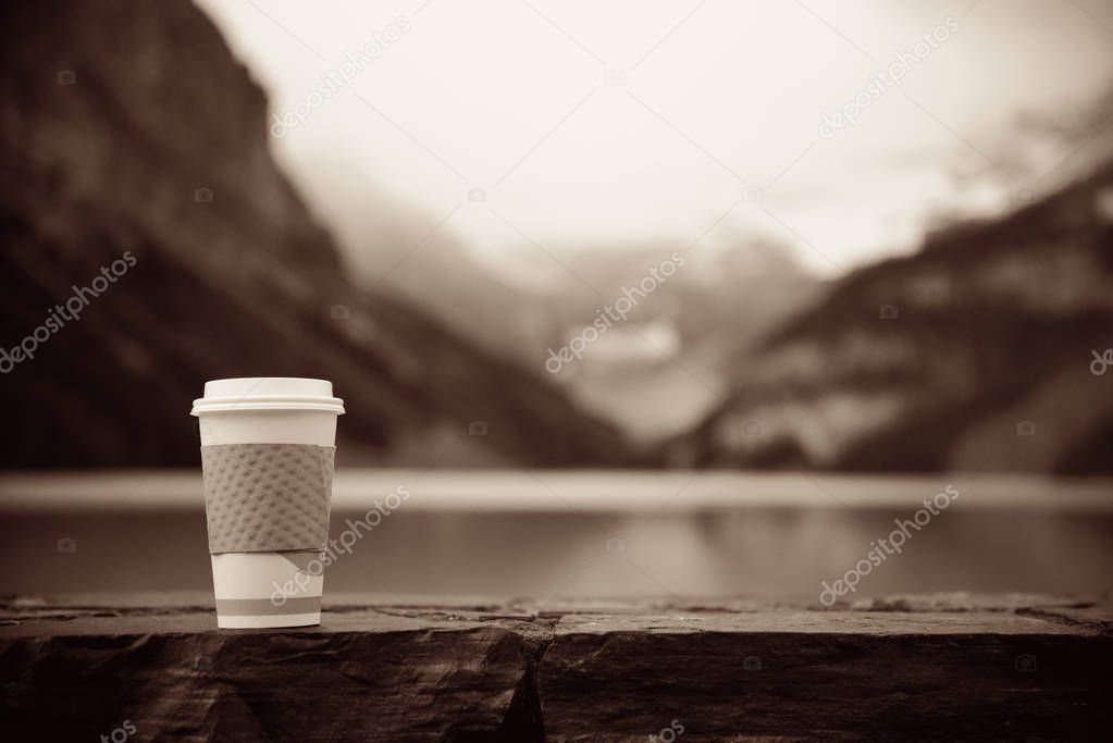 Lake Louise with coffee cup in Banff national park with mountains and forest in Canada.