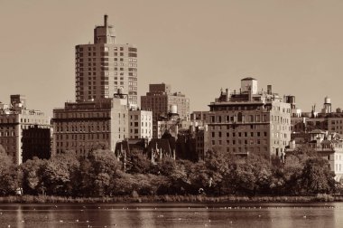 Central Park Manhattan, New York 'ta sonbaharda göl üzerindeki lüks bina..