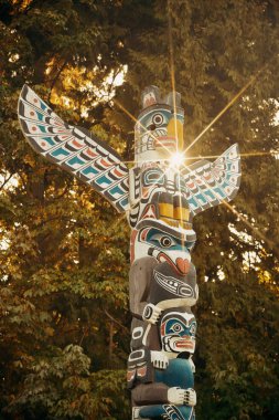 Kanada, Vancouver 'daki Stanley Parkı' nda güneş ışınlı Hint totem direkleri.