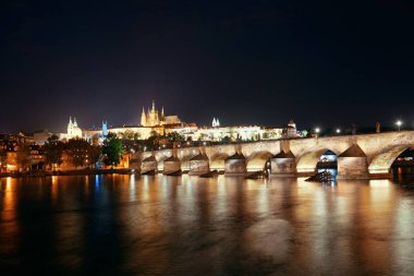 Geceleri Çek Cumhuriyeti 'nde Prag silueti ve nehir üzerinden köprü.