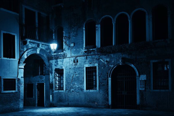 Venice alley at night with historical architectures in Italy.