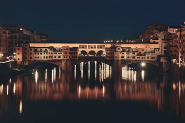 Ponte Vecchio gece Floransa 'da Arno Nehri üzerinde.