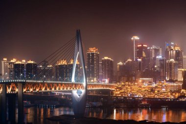 Qiansimen Bridge with Hongyadong shopping complex and city urban architecture at night in Chongqing, China. clipart