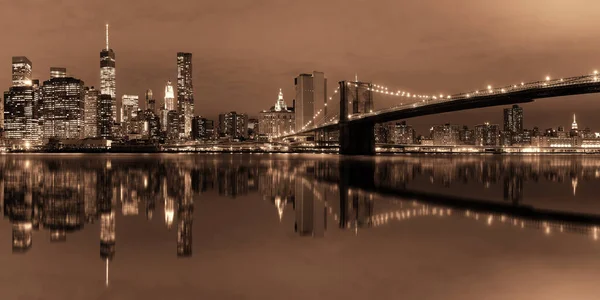 光が反射して夜のブルックリン橋とマンハッタン ダウンタウン アーバン ビュー — ストック写真