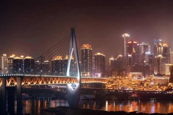 重庆市钱西门大桥与洪亚东购物中心及城市建筑的夜景 — 图库照片
