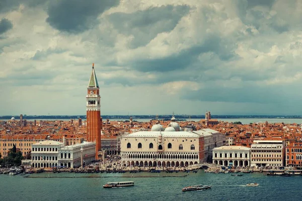 イタリアのヴェネツィアにあるサン ジョルジョ マッジョーレ島から見えるセント マークス教会の時計塔と都市スカイライン — ストック写真