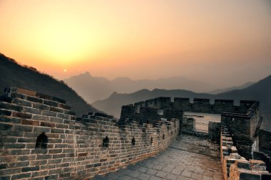 Çin 'in Pekin şehrinde sabah güneş doğarken ve gökyüzü renkliyken Çin Seddi..