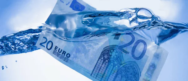 Money and business concept. Showing Euro banknote sinking in water as a symbol of global economic crisis
