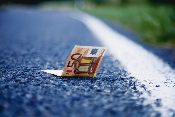 Good luck to find money as a symbol of profit. Euro banknotes on the road. Money, wealth, business, success concept.