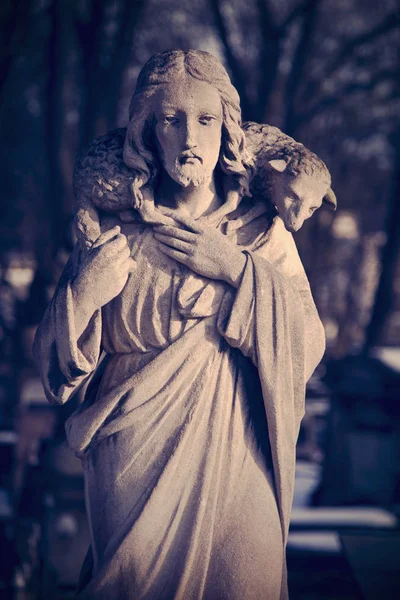 Retro and  dirty styled image of antique statue Jesus Christ Good Shepherd.