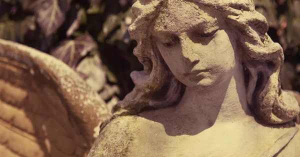 Bonito close up af um rosto escultura de pedra de anjo com um doce — Fotografia de Stock