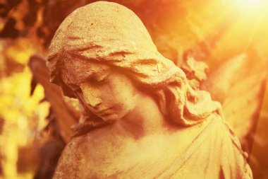 Güneş ışığı altında Altın melek antika heykeli. (din, inanç, ölüm, kıyamet, sonsuzluk kavramı)