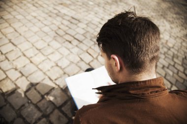 Genç adam yaşlı Europe şehirde kitap okumak 