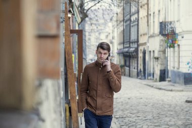 gülümseyen ve telefon açık havada konuşurken güneş gözlüklü genç işadamı